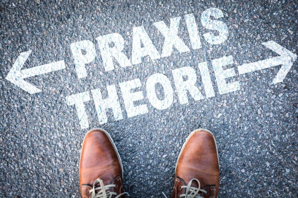 Schuhe auf Asphalt mit den Pfeilen 'Praxis' und 'Theorie' als Orientierung für den VKU-Zeitpunkt