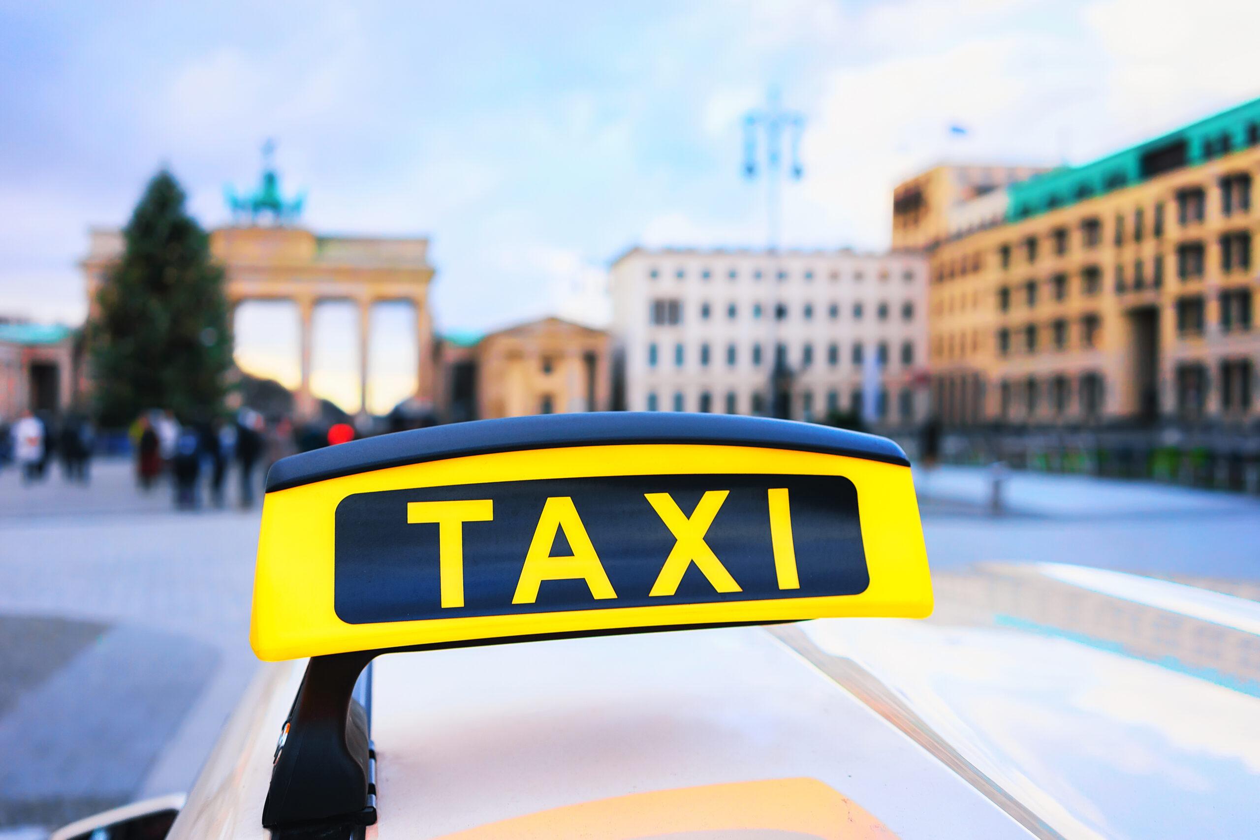 Ein Taxi-Schild vor dem Brandenburger Tor – Symbol für das Taxigewerbe in Deutschland.