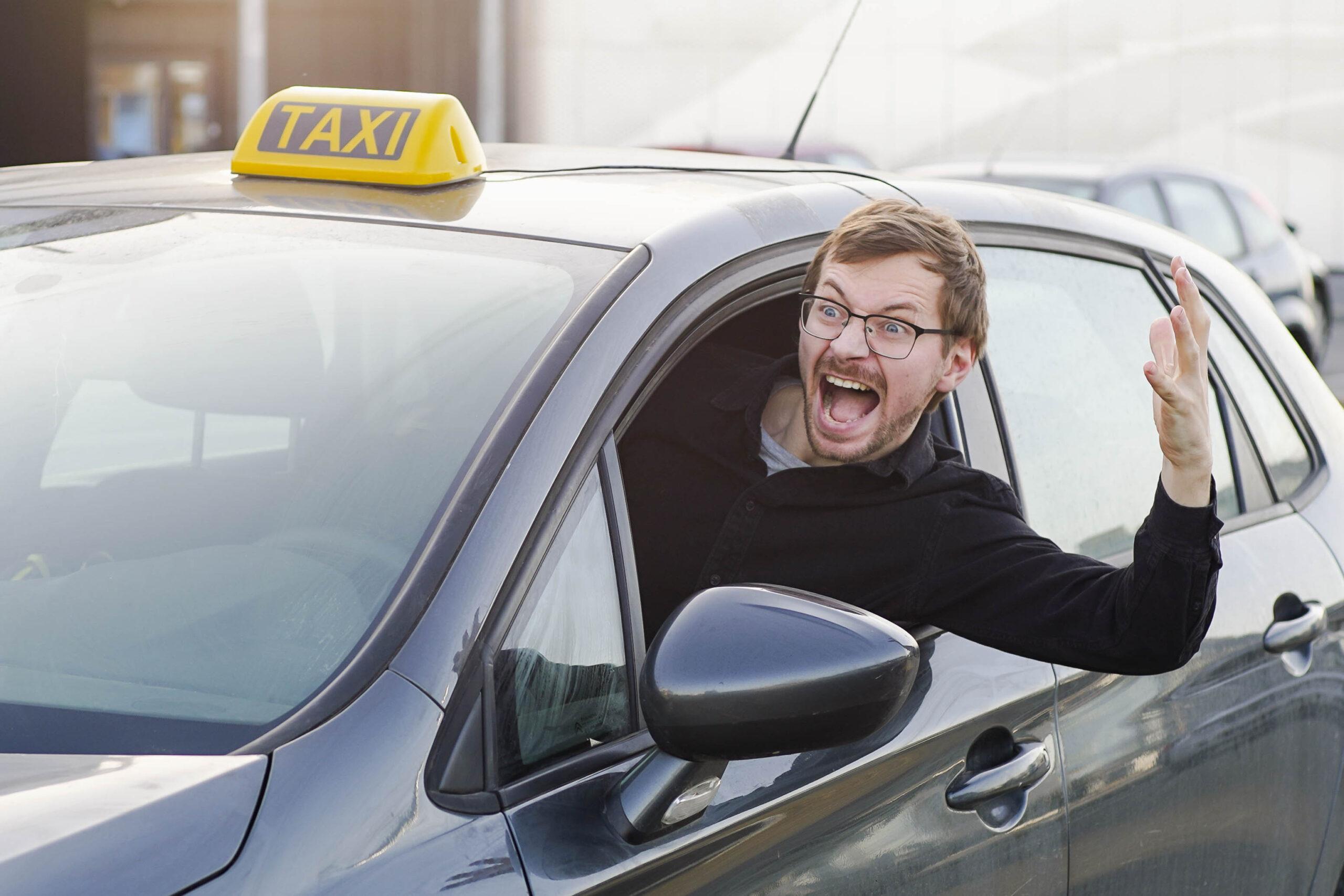 Ein Taxifahrer schaut aus dem Fenster und gestikuliert – Alltag im Taxi-Business.